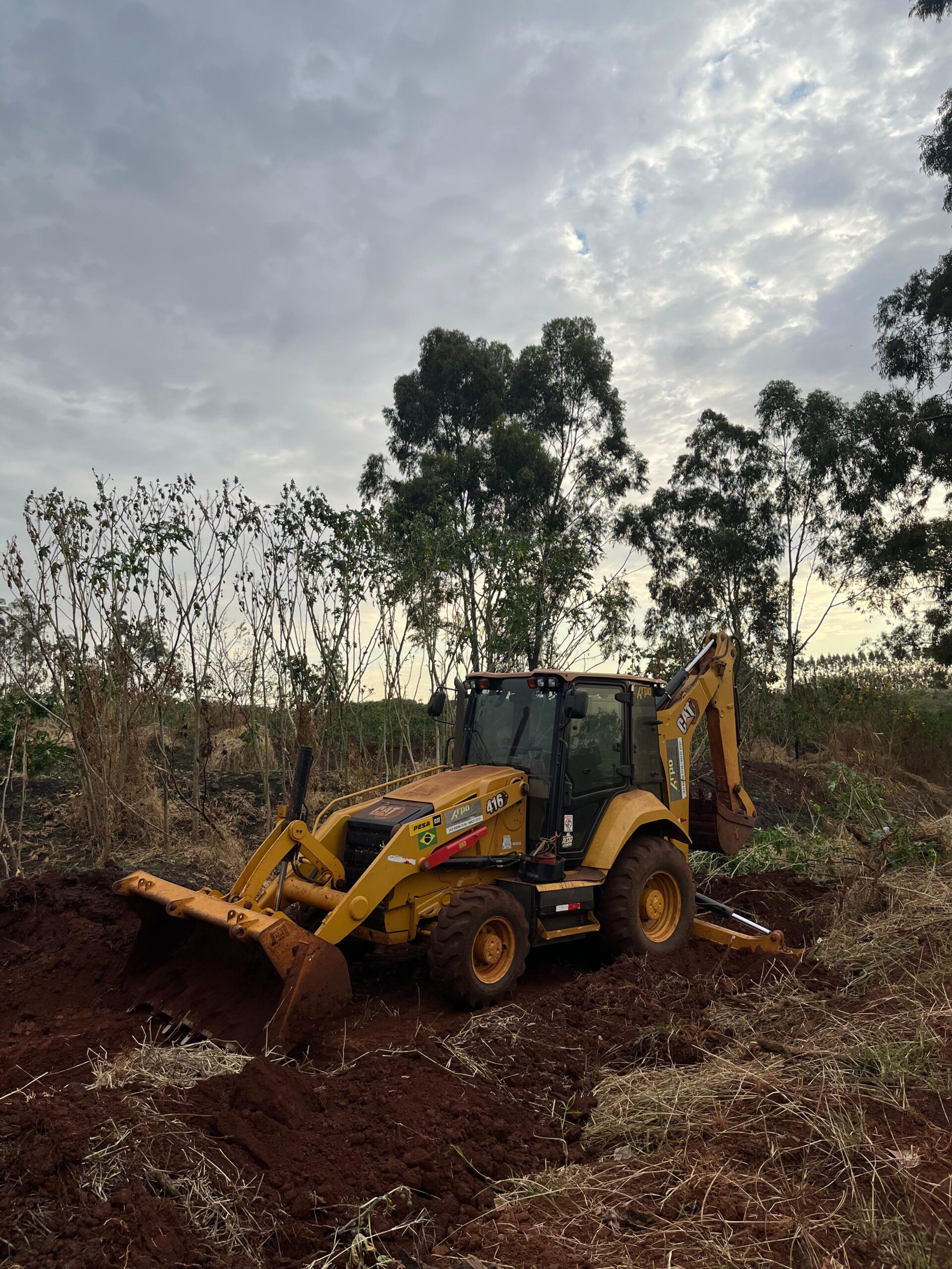 Retroescavadeira fazendo a limpeza de um terreno